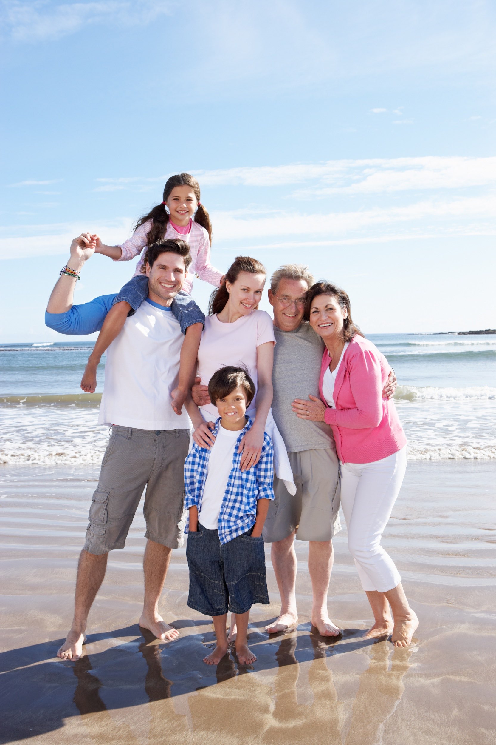 Multi Generation Family Having Fun On Beach Holiday